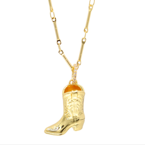 A gold necklace featuring a detailed cowboy boot pendant with western-style engravings, suspended from a gold chain on a plain white background.