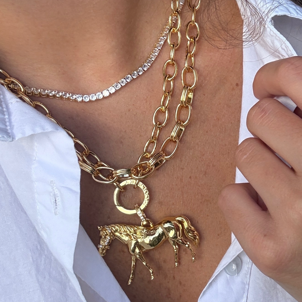 Large horse charm hanging from chunky gold chain