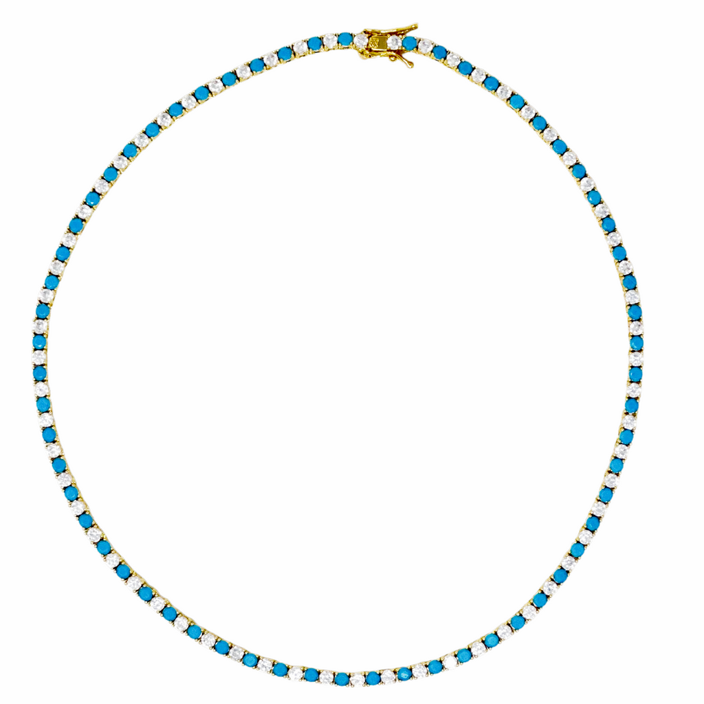 A tennis-style necklace with small bright blue stones and clear stones set in yellow gold, shown on a plain white background.