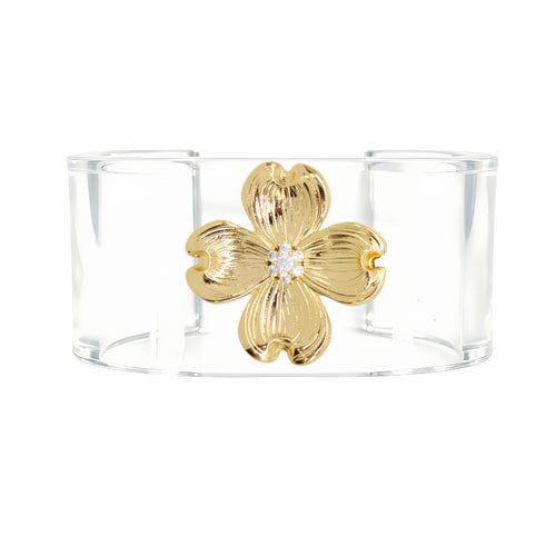 A clear acrylic cuff bracelet featuring a textured gold four-petal flower with a small clear crystal at its center, shown against a plain white background.